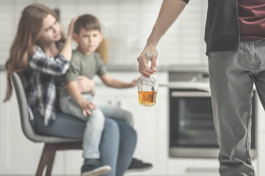 Мужчина с бутылкой алкоголя и его семья